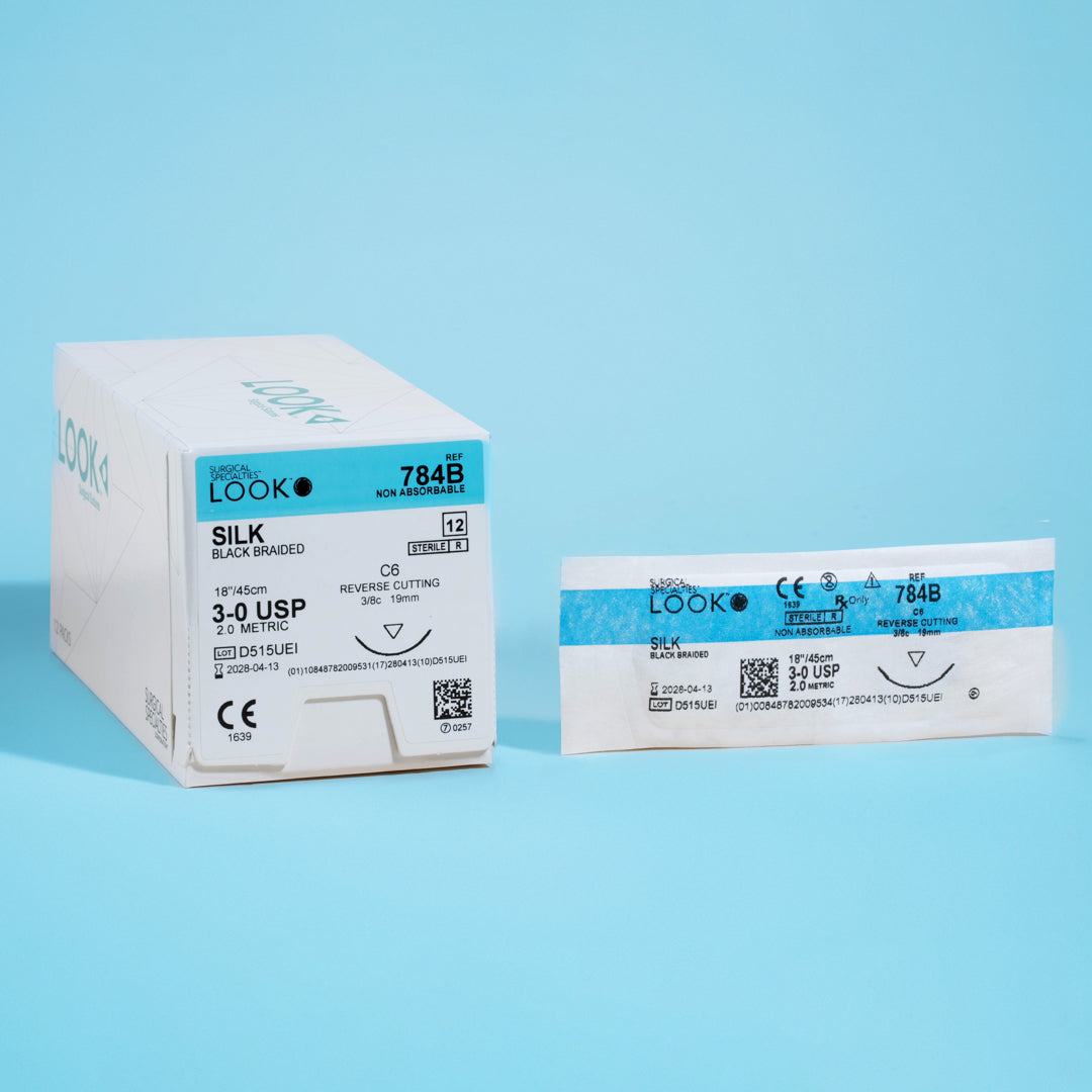 An image of a box and individual packet of 3-0 silk black braided sutures with an 18-inch C-6 reverse cutting needle. The box is labeled with reference number 784B, indicating the non-absorbable and sterile nature of the sutures, certified by a CE mark and a QR code for detailed product information. These sutures are tailored for surgeries demanding strong, lasting suture material with excellent knot security.
