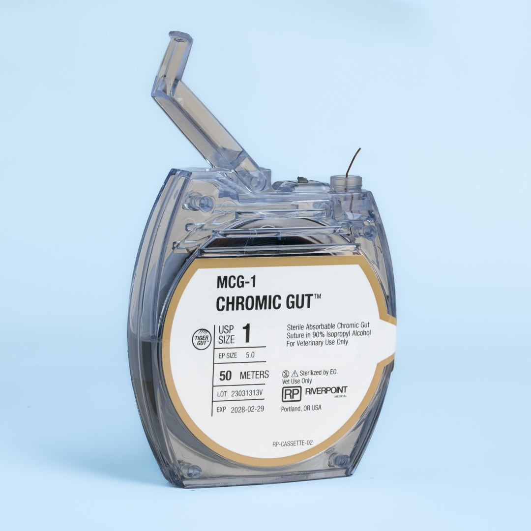 Close-up of the RIVERPOINT MCG-1 Chromic Gut suture cassette, showing a 50-meter violet suture coil, size 1 (Ep 5.0), designed for veterinary surgical use. The label details gamma irradiation sterilization, wound support for 2 weeks, and ethylene oxide (EO) sterilization method. Manufactured by RIVERPOINT in Portland, OR, USA, highlighting its suitability for various surgical applications with a focus on safety, performance, and ease of use.